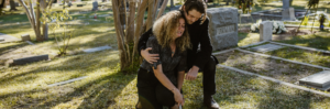 Man and woman grieving at a gravesite